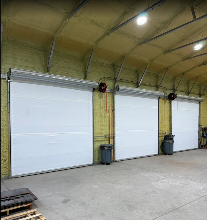 Commercial roll-up door coiled into drum above opening